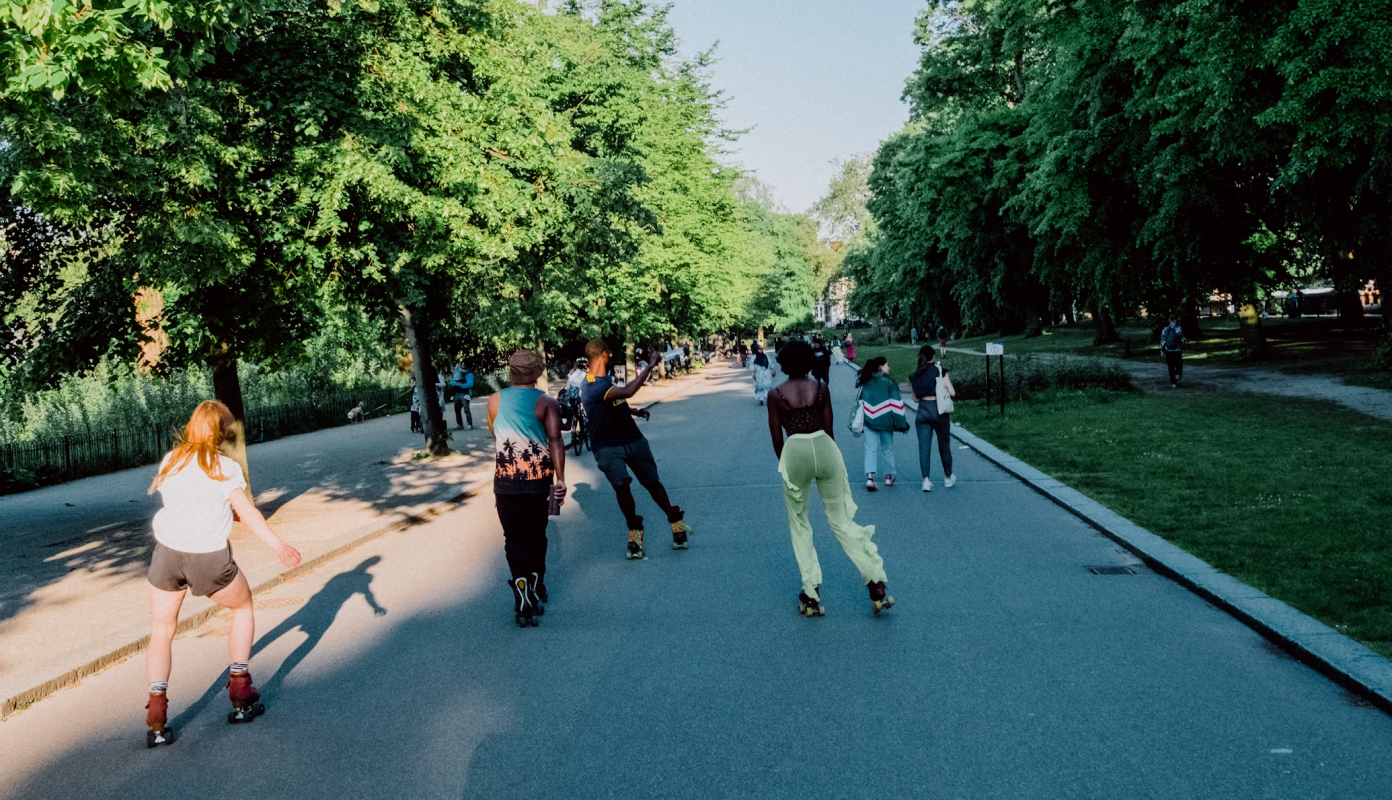 garota com patins numa quadra com uma das pernas para o alto